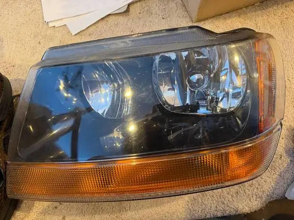 HEADLIGHT LEFT (DRIVER) ONLY 99-04 JEEP, POSS others