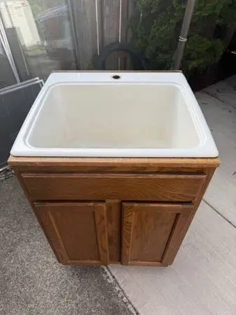 Utility sink in cabinet, no faucet.