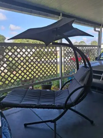 Outdoor hanging lounge chair with umbrella.