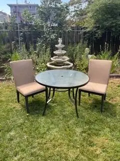 Bronze finish glass top bistro table and two outdoor parsons chairs