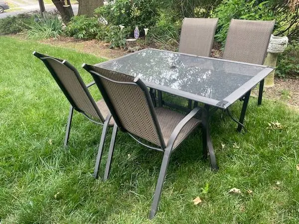 Dark bronze finish glass top patio table and four sling chairs