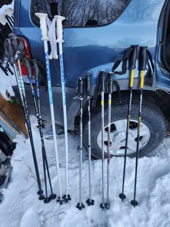 Various pairs of ski poles for adults and children