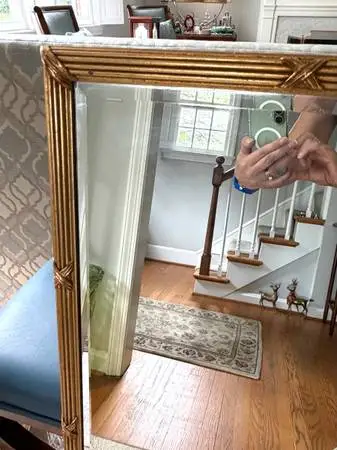Elegant wall mirror has a gold-finished frame with a reeded faux bamboo design a