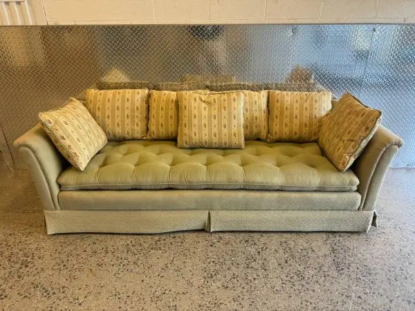 Vintage upholstered tufted sofa with throw back pillows