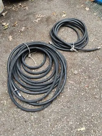 Two black rubber flexible water hoses