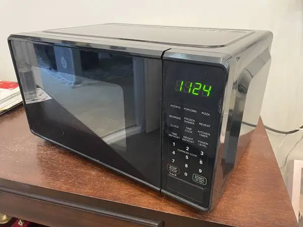 Small black microwave with turnstile