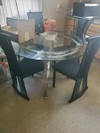 Glass  table with four black chairs