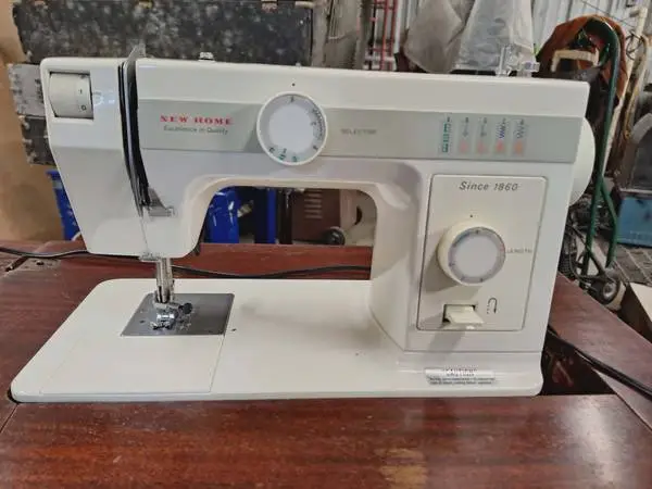 NEW HOME SEWING MACHINE in cabinet