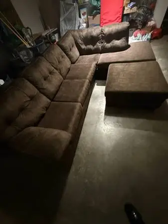 Brown sectional couch with ottoman and full size bed in couch