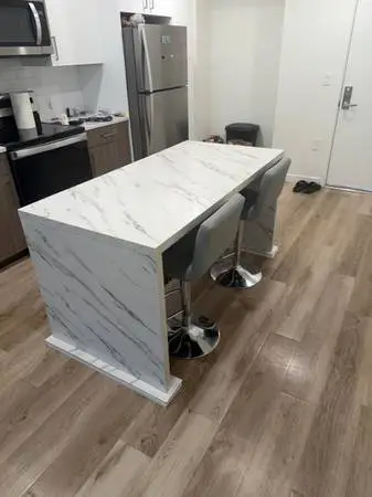 Marble type kitchen island with bar stools