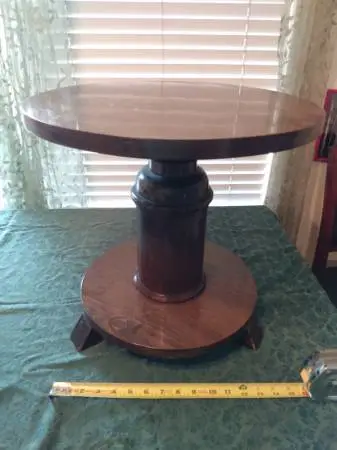 small round wooden accent table with milk can accent between shelves
