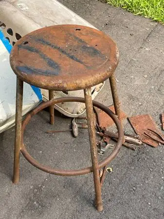 Worn rusted metal stool.