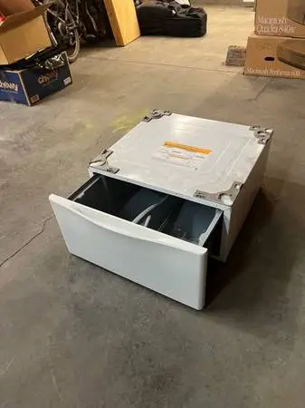 Storage drawer for underneath a washer or dryer