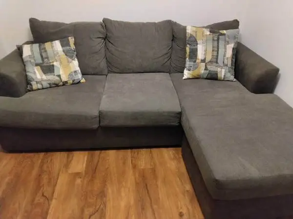 Grey sectional with two pillows $125
