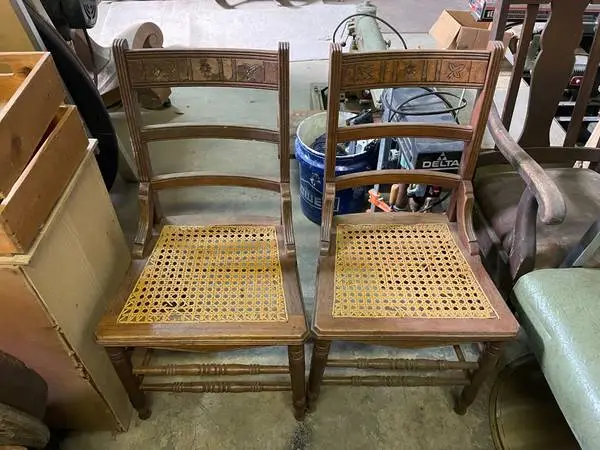 Two wooden chairs with cane seats