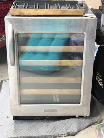 Stainless steel KitchenAid wine cooler with wooden shelves. Needs cool