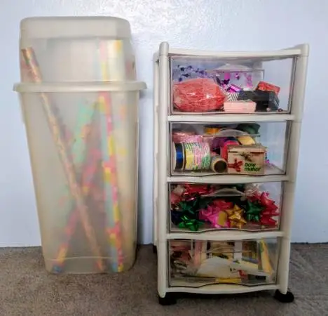 Two Rubbermaid Storage Containers filled with wrapping paper/ribbons, etc