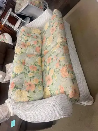 White wicker furniture set with floral cushions