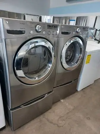 LG GREY WASHER AND DRYER SET ON PEDESTALS