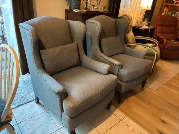 2 grey studded wingback chairs
