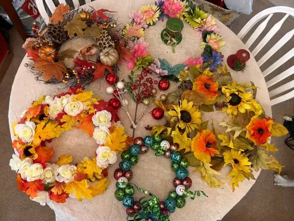 Several seasonal decorative wreaths and crafting materials.