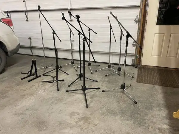 Lots of Microphone stands, most are boom type, one straight
