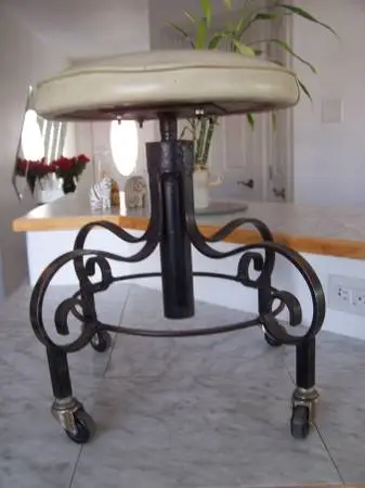 Vintage wrought iron swivel piano stool on casters
