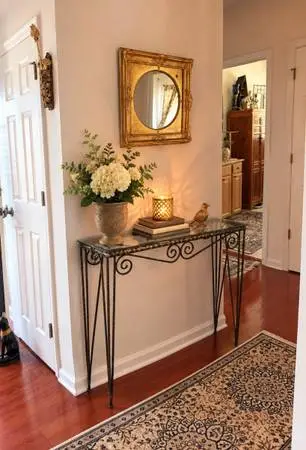 Beautiful wrought iron and glass console table with decorative scrollwork and sl