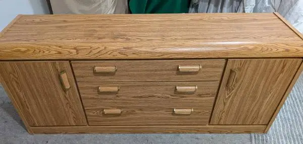 Brown dresser features brass-accented hardware and a Campaign-style!