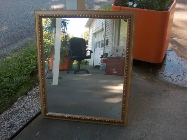 MIRROR IN GOLD WOOD FRAME.25 1/2 X 31 1/2 HANGS EITHER WAY.