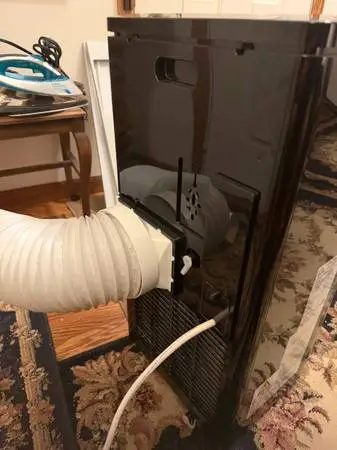 One room air conditioner sits inside and the hose goes out a double hung window.