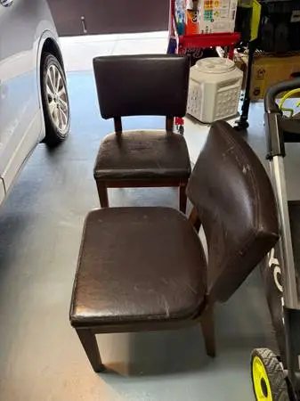 2 wood frame chairs with brown pleather upholstery