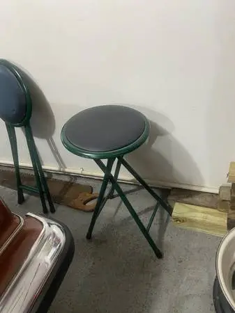 Set of two padded stools that fold up - green frame and black seat