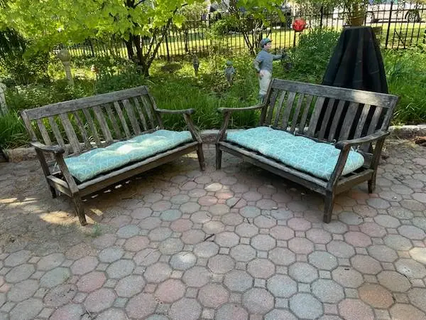 Pair of teak patio love seats with cushions