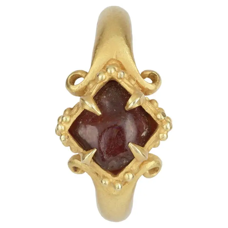 A Fine Temple Ring Set with a Rough Garnet and Raised, Lobed Bezel