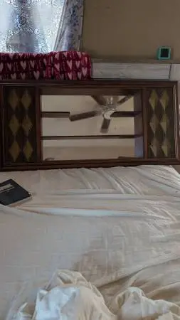 Wooden nik-nak shelf with mirror hangs on the wall