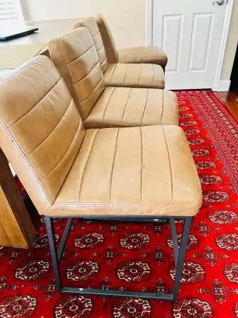 Four counter height stools/ chairs faux tan leather