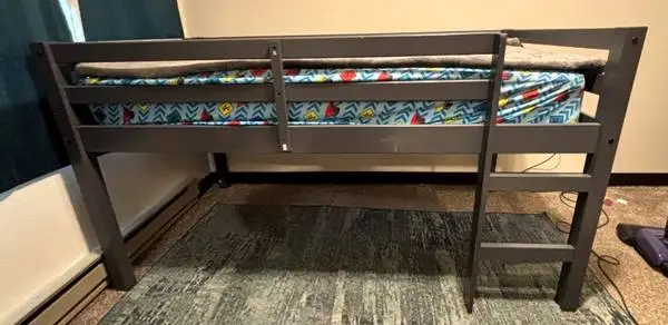 Gray wooden low loft bed frame has a built-in ladder