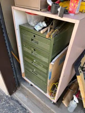 Four drawer metal cabinet sitting in box with caster’s