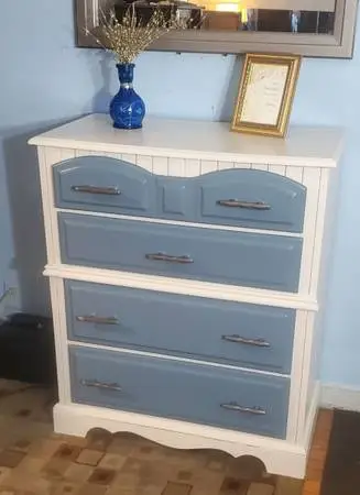 wooden dresser has a white frame with four blue drawers. This piece is construct