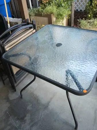 Brown glass patio table and four chairs
