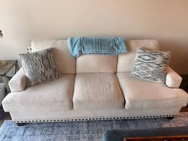 Beige 3-Seat Sofa with Decorative Studs and Accent Pillows