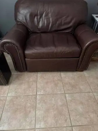 Brown Leather Loveseat that electronically extends for sleep.
