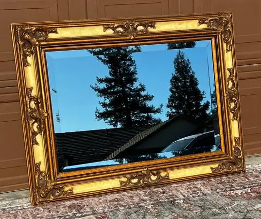 Ornate gilt wood framed beveled wall mirror