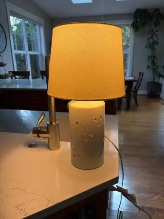 White ceramic lamp with star shaped base with cutouts that light up