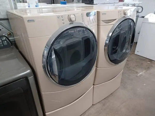 Kenmore Elite HE5 tan front load washer and dryer set on pedestals